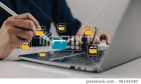 A paperless office built on e-documents. A man types on a laptop while viewing document icons on a virtual screen. 96148380