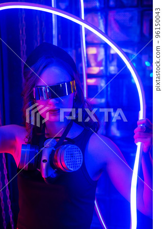 Caucasian woman in sunglasses posing in neon studio. 96150043