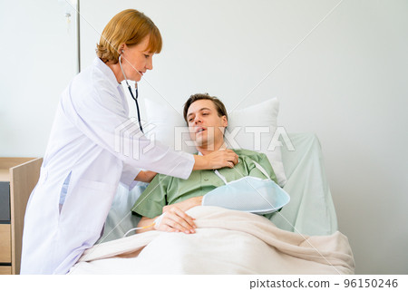 Senior doctor use stethoscope to check body health of young man patient who lie on bed 96150246