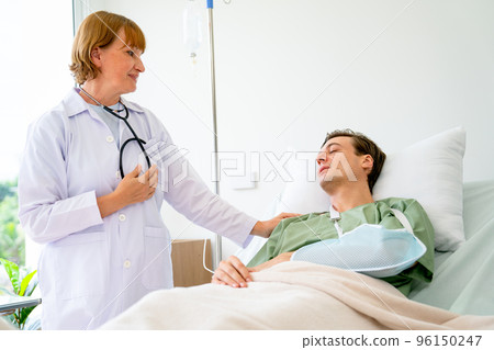 Caucasian woman doctor talk and discuss with young patient man who have arm problem Caucasian woman doctor talk and discuss with young patient man who have arm problem 96150247