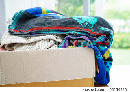 Clothes donations in cardboard box for volunteer. 96154713