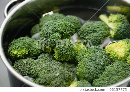 Fresh green broccoli cooked boiled in a pan. 96157775