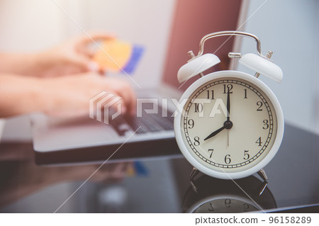 hand typing credit card number with time clock for online shopping times concept hand typing credit card number with time clock for online shopping times concept 96158289