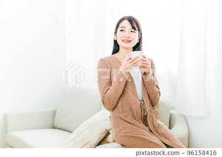 Women drinking hot drinks (tea, coffee, warmth, sofa) Women drinking hot drinks (tea, coffee, warmth, sofa) 96158416