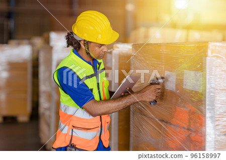 indian worker in logistics industry working inventory management system using barcode reader and tablet computer indian worker in logistics industry working inventory management system using barcode reader and tablet computer 96158997