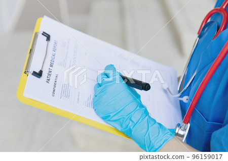 Doctor nurse writing followup information in medical examination document for patient health check in hospital or clinic. 96159017