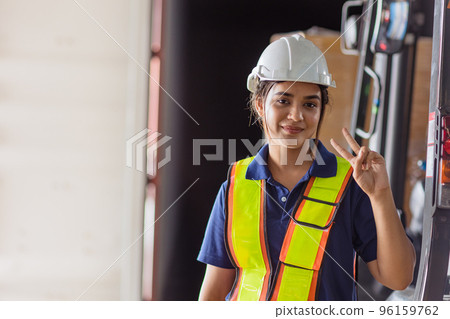 happy woman engineer worker Asian Latin Indian. lady staff in safety suit work in large factory warehouse cute action happy woman engineer worker Asian Latin Indian. lady staff in safety suit work in large factory warehouse cute action 96159762