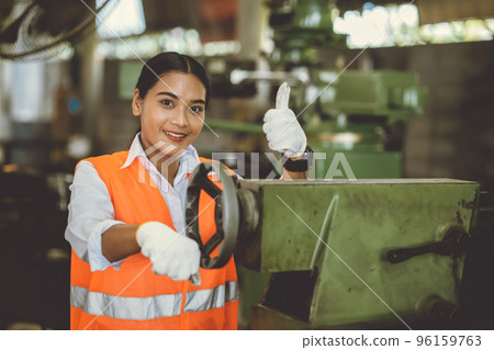 portrait happy woman worker working in heavy industry metal factory Asian smiling thumbs up portrait happy woman worker working in heavy industry metal factory Asian smiling thumbs up 96159763
