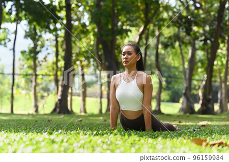 Young woman stretching, practicing yoga in high cobra asana pose. Yoga, meditation and healthy lifestyle concept 96159984