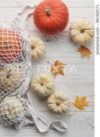 Top view autumn composition with pumpkins in mesh shopping bag Top view autumn composition with pumpkins in mesh shopping bag 96160571
