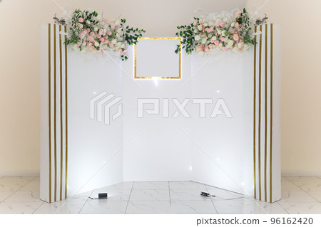 White photo zone with delicate flowers for the hero of the day in the cafe 96162420