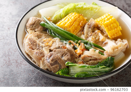 Bulalo is a beef dish from the Philippines soup made by cooking beef shanks and bone marrow with cabbage, corn, scallions, onions, garlic and fish sauce closeup. Horizontal 96162703