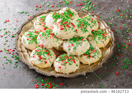 Italian Christmas Cookies are delicious cake-like cookies with a hint of anise and sweet sugar glaze closeup in the plate. Horizontal 96162713