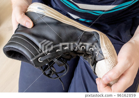 Old torn shoe in hands of man Old torn shoe in hands of man 96162859