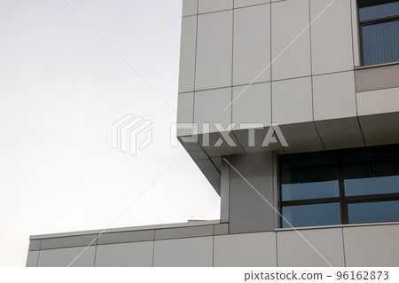 Corner of modern building against gray sky Corner of modern building against gray sky 96162873
