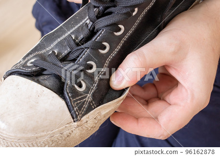 Old torn shoe in hands of man 96162878