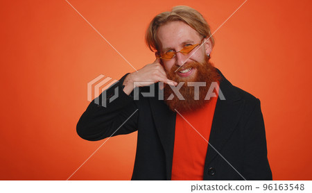 Cheerful one man in jacket looking at camera doing phone gesture like says hey you call me back Cheerful one man in jacket looking at camera doing phone gesture like says hey you call me back 96163548