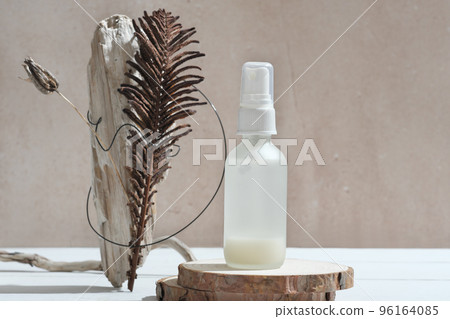 face care serum in white bottle on natural wooden podium next to modern still life set. two-phase age defying serum, fermented cosmetic with bifida lysates. 96164085