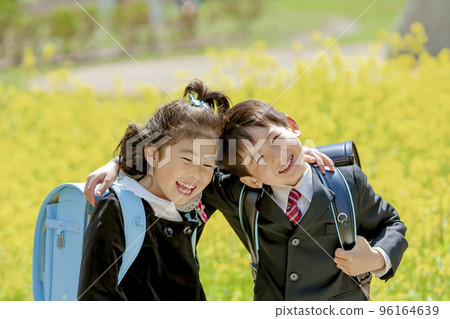 一年級學生背著書包在油菜花盛開的公園裡 一年級學生背著書包在油菜花盛開的公園裡 96164639