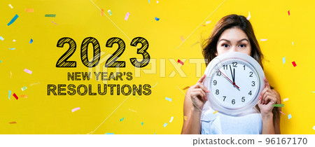 2023 New Years Resolutions with young woman holding a clock 96167170
