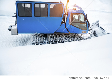 Rear back door window view blue modern snowcat ratrack grooming machine with cabine box preparing ski slope piste alpine skiing resort. ATV arctic vehicle forest winter tundra trip adventure travel Rear back door window view blue modern snowcat ratrack grooming machine with cabine box preparing ski slope piste alpine skiing resort. ATV arctic vehicle forest winter tundra trip adventure travel 96167557