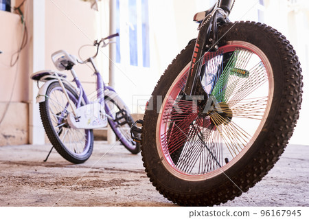 a bike parked in front of a building with the wheel leaning on it's rims and spokes a bike parked in front of a building with the wheel leaning on it's rims and spokes 96167945