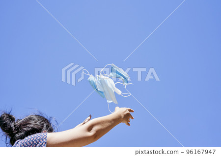 a woman flying a kite in the air with a blue sky behind her she is looking up at the sky a woman flying a kite in the air with a blue sky behind her she is looking up at the sky 96167947