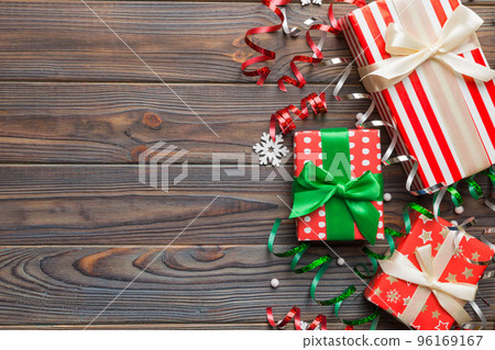 Holiday flat lay with gift boxes wrapped in colorful paper and tied decorated with confetti on colored background. Christmas, Birthday, Valentine and sale concept, top view Holiday flat lay with gift boxes wrapped in colorful paper and tied decorated with confetti on colored background. Christmas, Birthday, Valentine and sale concept, top view 96169167
