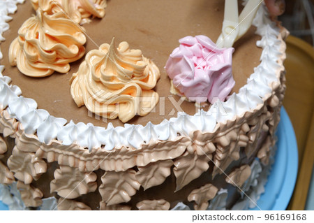 Confectioner woman is pouring cream on sponge cake using pastry bag, closeup view. Pastry chef is cooking homemade cake. cooking, baking and cooking, home cooking Confectioner woman is pouring cream on sponge cake using pastry bag, closeup view. Pastry chef is cooking homemade cake. cooking, baking and cooking, home cooking 96169168