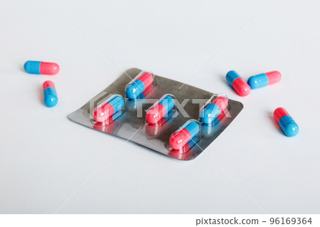 Medicine pills on a light background. Medicines and prescription pills flat lay background. Blue and pink medical tablets in blister 96169364
