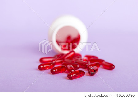 Red pills spilled around a pill bottle. Medicines and prescription pills flat lay background. Red medical capsules 96169380