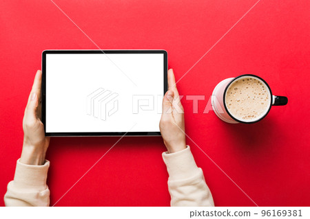 Close up image woman hands holding digital tablet with blank copy space screen for your text message or promotional content om table with cup of coffee. hands of a woman holding blank tablet device 96169381