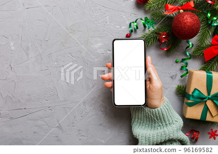 christmas mockup with space for text. christmas advertising, app template. hand holding phone with empty screen on table background. Happy New Year and Xmas Flat lay christmas mockup with space for text. christmas advertising, app template. hand holding phone with empty screen on table background. Happy New Year and Xmas Flat lay 96169582