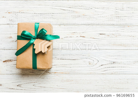 wrapped christmas or other holiday handmade present in paper with colored ribbon. Present box, decoration of gift on colourfull table, top view with copy space 96169655