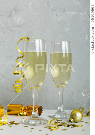 Champagne glasses and christmas decor on colored holiday background. Flat lay New Year decorations Champagne glasses and christmas decor on colored holiday background. Flat lay New Year decorations 96169668