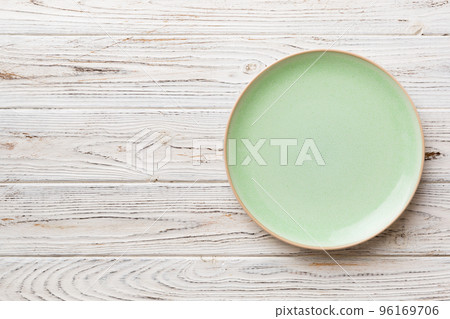 Top view of empty green plate on wooden background. Empty space for your design Top view of empty green plate on wooden background. Empty space for your design 96169706
