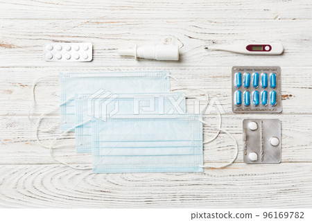 Protective face masks or surgical masks, medicine pills and thermometer on table background. Coronavirus disease. Corona virus concept. Space for text 96169782