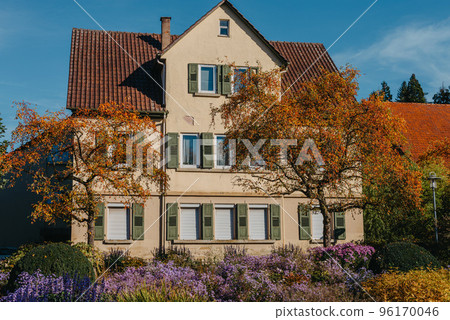 House with nice garden in fall. Flowers in the City Park of Bietigheim-Bissingen, Baden-Wuerttemberg, Germany, Europe. Autumn Park and house, nobody, bush and grenery House with nice garden in fall. Flowers in the City Park of Bietigheim-Bissingen, Baden-Wuerttemberg, Germany, Europe. Autumn Park and house, nobody, bush and grenery 96170046