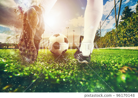 Close up scene at soccer field with a soccer shoe hitting the ball during training 96170148