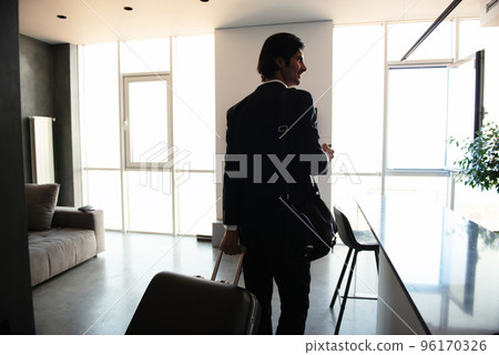 Businessman at the phone ready to travel. 96170326