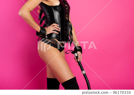 Sensual provocation of a sexy bdsm woman in lingerie with whip. Fuchsia background Sensual provocation of a sexy bdsm woman in lingerie with whip. Fuchsia background 96170338