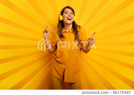 Girl with yellow headset listens to music and dances. emotional and energetic expression 96170485