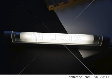 LED lamp on the desk. Glowing fluorescent lamp and LED on a black table. LED lamp on the desk. Glowing fluorescent lamp and LED on a black table. 96170514