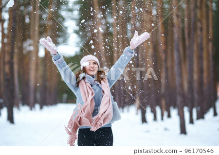 Cute young woman is playing with snow in the forest. Winter lifestyle happiness emotions nature. 96170546