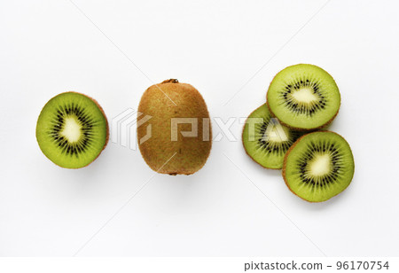 Chopped fruit of green juicy kiwi on a white background. Delicious kiwi slices close-up. Chopped fruit of green juicy kiwi on a white background. Delicious kiwi slices close-up. 96170754