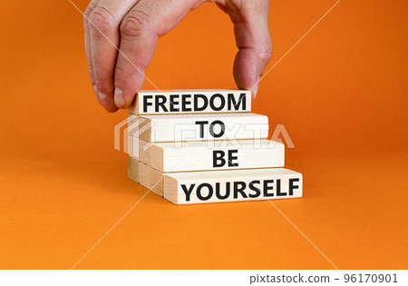 Freedom to be yourself symbol. Concept words Freedom to be yourself on wooden blocks on a beautiful orange background. Businessman hand. Business, psychological freedom to be yourself concept. Freedom to be yourself symbol. Concept words Freedom to be yourself on wooden blocks on a beautiful orange background. Businessman hand. Business, psychological freedom to be yourself concept. 96170901