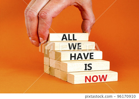 All we have is now symbol. Concept words All we have is now on wooden blocks. Businessman hand. Beautiful orange table orange background. Business, motivational all we have is now concept. Copy space. 96170910
