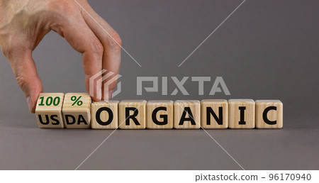 100 percent organic symbol. Fliped wooden cubes and changed words USDA organic to 100 percent organic. Beautiful grey background, copy space. Business, healthy lifestyle 100 percent organic concept. 96170940