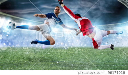 Goalkeeper catches the ball in the stadium during a football game. 96171016