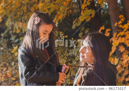 Mother and her little daughter in autumn park in fall season. Mother and her little daughter in autumn park in fall season. 96171017